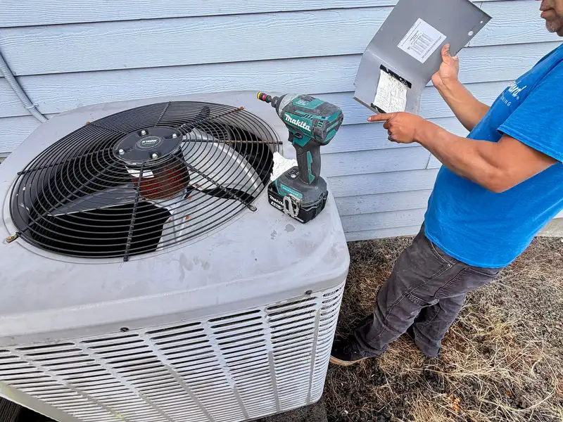 Pacific Breeze HVAC technician testing a residential air conditioning condenser